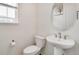Bathroom featuring a toilet, sink and round mirror at 12777 Clearview St, Firestone, CO 80504