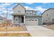 Two-story home boasting a front porch, two-car garage, manicured lawn, and inviting curb appeal at 12777 Clearview St, Firestone, CO 80504