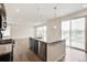 Modern kitchen featuring a large island, stainless steel appliances, granite countertops, and wood floors, with sliding glass doors at 12777 Clearview St, Firestone, CO 80504