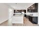 Elegant kitchen with stainless steel appliances, dark cabinets, a granite island, and sliding door access to the backyard at 12777 Clearview St, Firestone, CO 80504