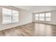 Spacious living room with wood floors, recessed lights, and large windows creating a light-filled space at 12777 Clearview St, Firestone, CO 80504
