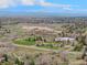 Expansive aerial view showcasing a community with a park, school, and scenic mountain backdrop at 7888 S Magnolia Way, Centennial, CO 80112