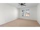 Neutral bedroom featuring a ceiling fan, carpeted floors and a large window with neighborhood views at 1150 Maddox Ct, Broomfield, CO 80023