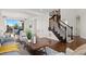 Open-concept living space with staircase, hardwood floors, and seamless transition to dining area with views at 1150 Maddox Ct, Broomfield, CO 80023