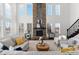 Sunlit living room featuring a stone fireplace, hardwood floors, large windows, and stylish furniture at 1150 Maddox Ct, Broomfield, CO 80023