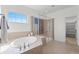 Bright main bathroom featuring an oval soaking tub, tiled shower, and tiled flooring at 1150 Maddox Ct, Broomfield, CO 80023