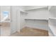 Spacious walk-in closet with shelving and carpeted floors with views of the main bathroom at 1150 Maddox Ct, Broomfield, CO 80023