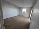 A simple bedroom has neutral carpet and a bright window at 6009 Yarrow St # C, Arvada, CO 80004