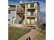 Exterior view of apartment complex with well-maintained lawn, sidewalk, and assigned parking spaces at 6009 Yarrow St # C, Arvada, CO 80004