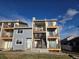 Apartment complex with landscaped front, showcasing upper and lower balconies with metal railings at 6009 Yarrow St # C, Arvada, CO 80004