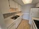 Efficient kitchen featuring white cabinets, stainless steel sink, and white appliances at 6009 Yarrow St # C, Arvada, CO 80004