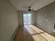 Bright empty room with hardwood floors, ceiling fan, and sliding glass door with natural light at 6009 Yarrow St # C, Arvada, CO 80004