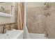 Bathroom with tiled shower and tub, shower caddy, and modern sink faucet at 1448 Depew St, Lakewood, CO 80214