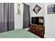 Bedroom view featuring dark wooden dresser with TV and grey accent curtains at 1448 Depew St, Lakewood, CO 80214