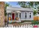 Charming blue home with a red door, a cozy front porch, and flower boxes, complemented by a white picket fence and swing at 1448 Depew St, Lakewood, CO 80214