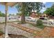 Cozy front yard with a decorative rock garden, mature shade tree, and a classic white picket fence, providing a welcoming entrance at 1448 Depew St, Lakewood, CO 80214