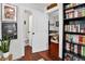 Hallway leading to a half bath and living area, with hardwood floors and built-in bookcase at 1448 Depew St, Lakewood, CO 80214