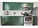 Modern kitchen features green cabinets, stainless steel appliances, and bright countertops at 1448 Depew St, Lakewood, CO 80214