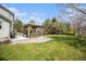 Spacious backyard with a well-maintained lawn, mature trees, and a charming covered patio, perfect for outdoor enjoyment at 6092 S Ouray St, Aurora, CO 80016