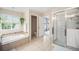 Bright bathroom boasting a separate tub and shower, tile flooring, and a large window providing ample natural light at 6092 S Ouray St, Aurora, CO 80016