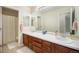 Bright bathroom featuring a double sink vanity, large mirror, and a shower-tub combo with a yellow floral shower curtain at 6092 S Ouray St, Aurora, CO 80016