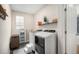 Well-lit laundry room with modern washer and dryer, a shelving unit, a drying rack, and dark wood-look flooring at 6092 S Ouray St, Aurora, CO 80016