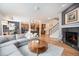 Open-concept living room features a fireplace, wood floors, and comfortable gray couch at 6092 S Ouray St, Aurora, CO 80016