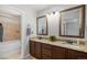 Bathroom featuring double sinks with granite countertops, updated fixtures, and a tub at 10359 Tracewood Dr, Highlands Ranch, CO 80130