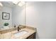 Half-bathroom featuring a granite countertop, modern faucet, and decorative mirror at 10359 Tracewood Dr, Highlands Ranch, CO 80130