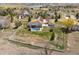 Aerial view of fenced property with lush landscaping, pool, deck, and a detached garage at 212 Mulligan Lake Dr, Mead, CO 80542