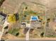 Aerial view of the home showcases a pool, fenced yard, landscape, and detached garage at 212 Mulligan Lake Dr, Mead, CO 80542