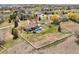 Aerial view of fenced property with lush landscaping, pool, deck, and a detached garage at 212 Mulligan Lake Dr, Mead, CO 80542