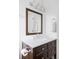 Bathroom with a dark wood vanity and white countertop, framed mirror and great natural light at 212 Mulligan Lake Dr, Mead, CO 80542