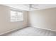 This bedroom features neutral walls, gray carpet, a ceiling fan, and a bright window at 212 Mulligan Lake Dr, Mead, CO 80542