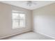 This is a bedroom with neutral carpet and paint, a large window with natural light and a ceiling fan at 212 Mulligan Lake Dr, Mead, CO 80542