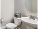 Cozy half bath with a stylish round mirror, a modern toilet, and a compact but elegant sink at 9786 Rosalee Peak St, Littleton, CO 80125