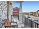 Cozy front porch featuring a sitting area, stone-detailed columns, and a view of the street at 9786 Rosalee Peak St, Littleton, CO 80125