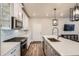 Bright kitchen features stainless steel appliances, a center island with quartz countertops, and ample cabinet space at 9786 Rosalee Peak St, Littleton, CO 80125