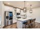 Modern kitchen featuring white cabinetry, stainless steel appliances, quartz countertops, and stylish pendant lighting at 9786 Rosalee Peak St, Littleton, CO 80125