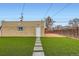 Backyard with artificial grass, stone pathway leading to a detached garage and a wooden fence at 3020 Niagara St, Denver, CO 80207