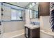 Well-lit bathroom with a shower-tub combo, blue and white tile, and a modern vanity at 3020 Niagara St, Denver, CO 80207