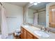 Bathroom featuring a double vanity, granite countertop, toilet, and framed mirror at 3354 Wabash St, Denver, CO 80238