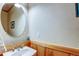 Bathroom featuring a pedestal sink, an oval mirror, and wood paneling at 3354 Wabash St, Denver, CO 80238