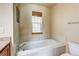 Bathroom featuring a large white tub, tile, and natural light at 3354 Wabash St, Denver, CO 80238