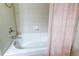 Bathroom with white bathtub, tile surround, shower curtain and chrome shower head at 3354 Wabash St, Denver, CO 80238