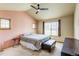 Cozy bedroom with pink walls, ceiling fan, two windows, and carpet flooring at 3354 Wabash St, Denver, CO 80238