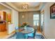 Cozy dining room features a round table with seating for four, a modern chandelier, and natural light from a window at 3354 Wabash St, Denver, CO 80238
