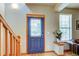 Bright entryway with a wooden staircase, stylish blue door and hardwood floors at 3354 Wabash St, Denver, CO 80238