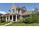 Stylish gray two-story house showcasing a cozy front porch and lush greenery at 3354 Wabash St, Denver, CO 80238