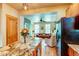 Open kitchen featuring marble countertops and stainless steel refrigerator leading to a naturally lit living room at 3354 Wabash St, Denver, CO 80238